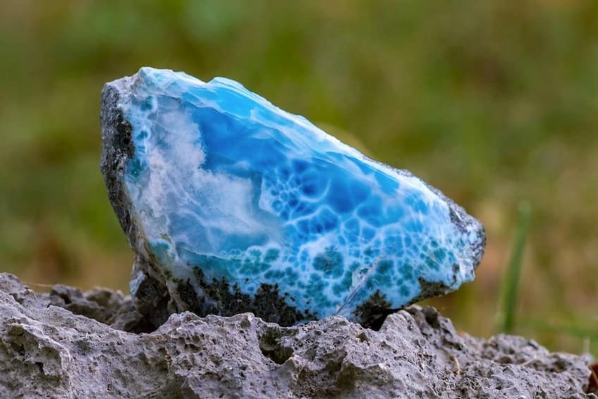 Piedras de larimar dominicano pulidas mostrando vetas de color azul celeste y patrones marinos.